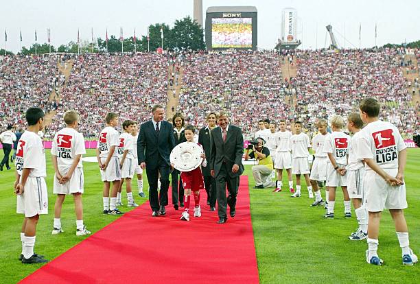 MUNICH, GERMANY - AUGUST 01:  1. Bundesliga 03/04, Muenchen; FC Bayern Muenchen - Eintracht Frankfurt 3:1; Vorstandsvorsitzender Bayern Muenchen AG Karl-Heinz RUMMENIGGE, Kind mit der Meisterschale, DFL Praesident Werner HACKMANN  (Photo by Andreas Rentz/Bongarts/Getty Images)